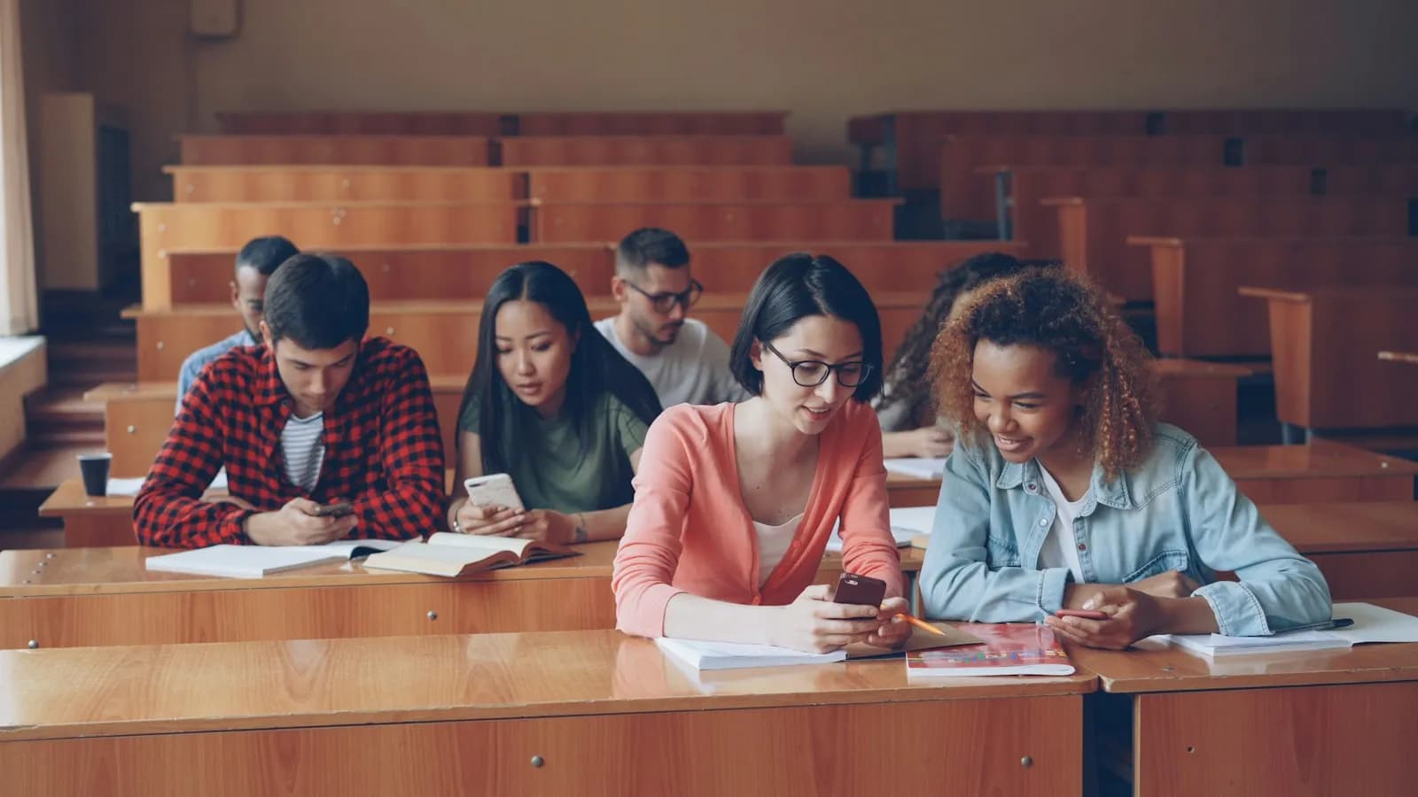 Students in a lecture hall looking at their phones