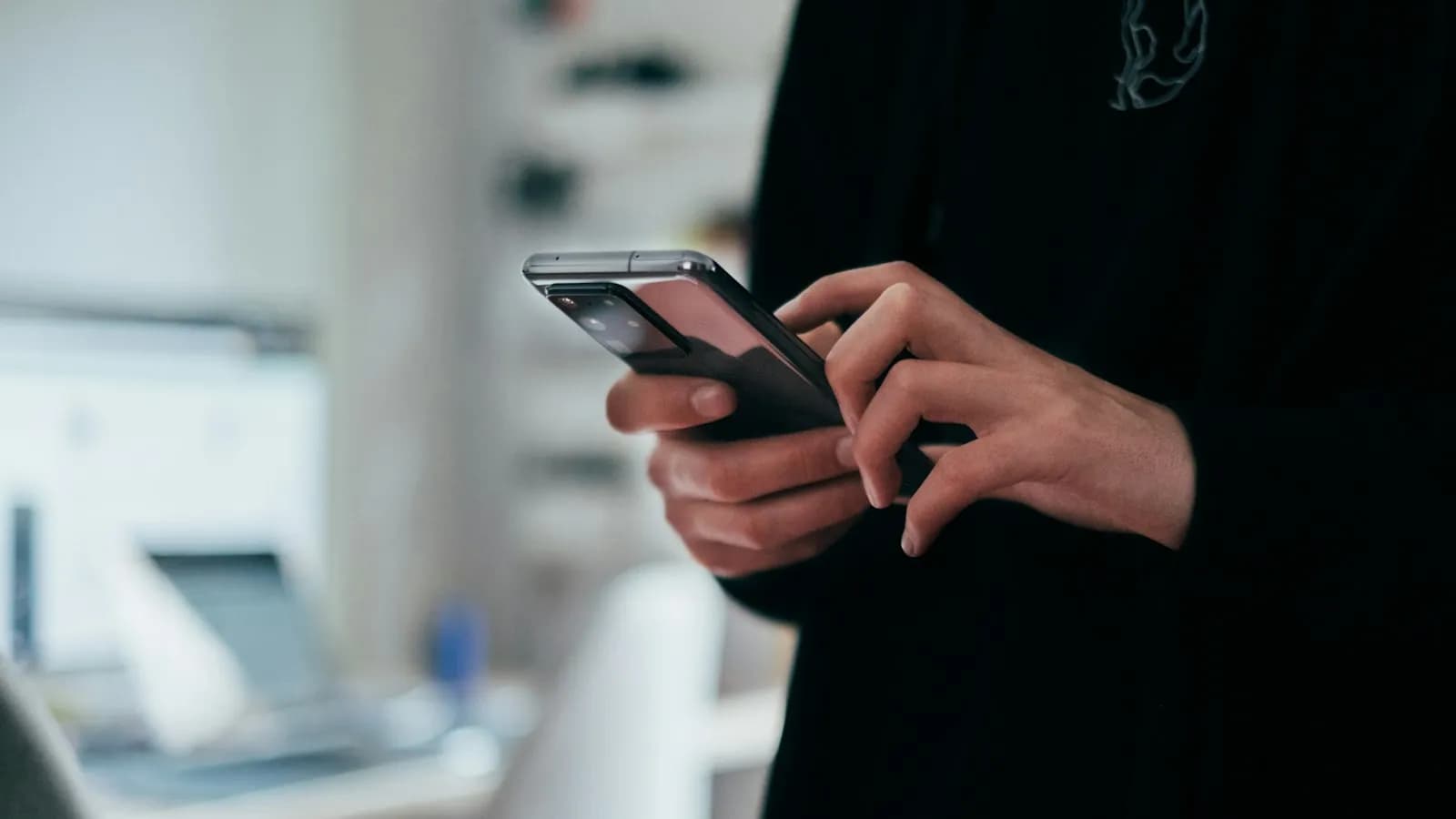 A person holding a smartphone and browsing a website