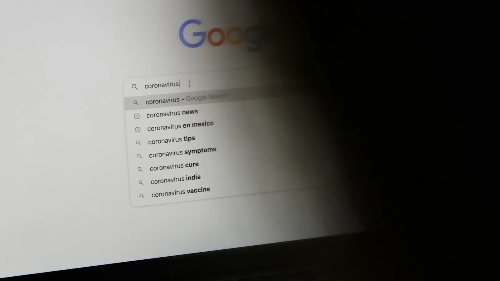 A Google search box on a computer screen with suggested searches below it