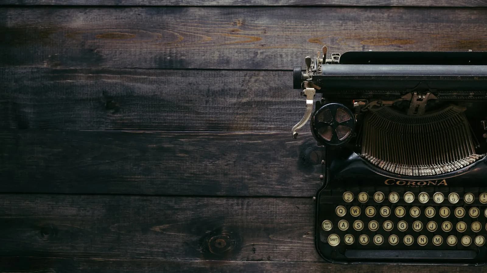 A vintage black typewriter on dark wooden planks