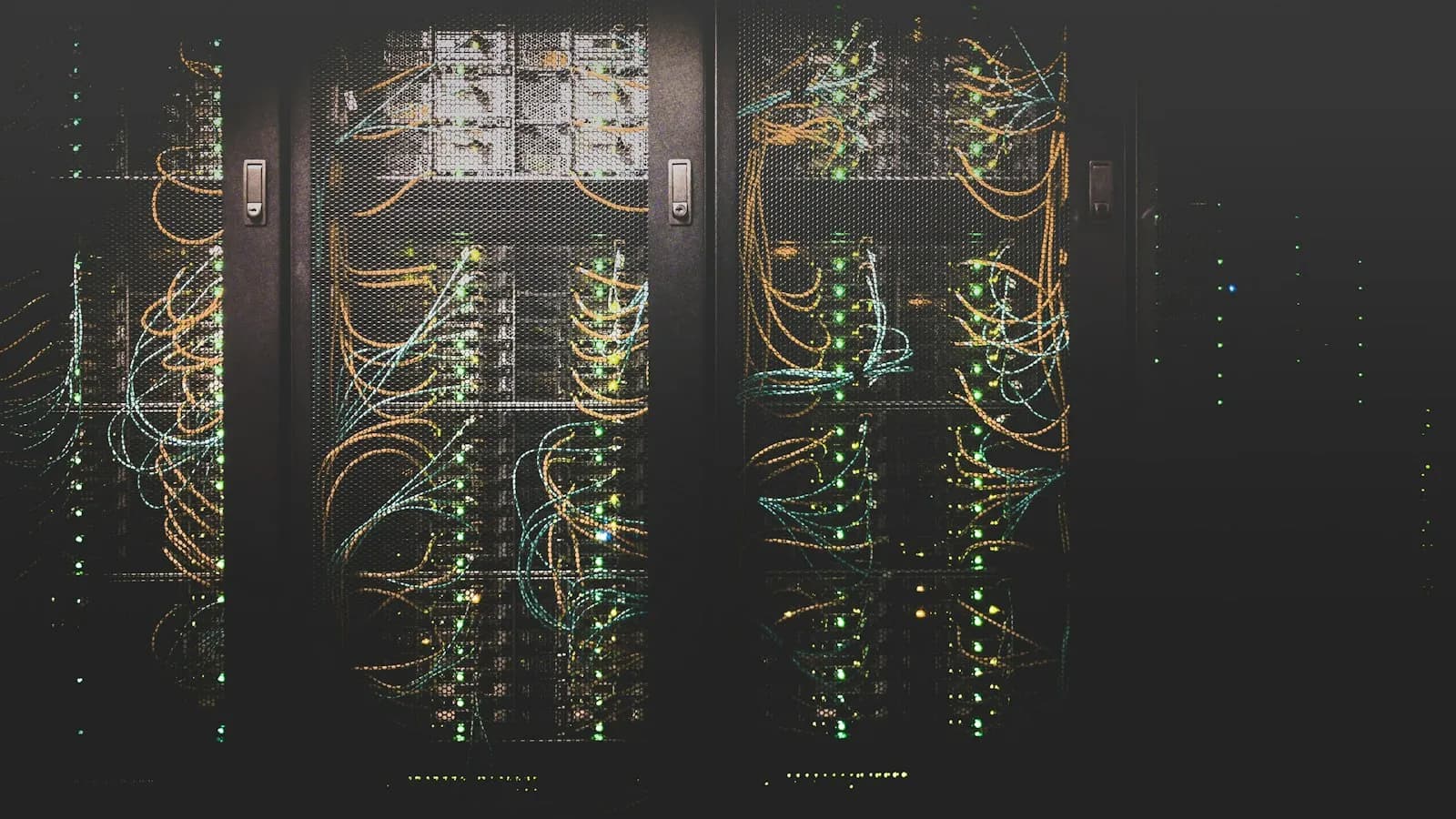 Rows of server racks with bundles of coloured network cables