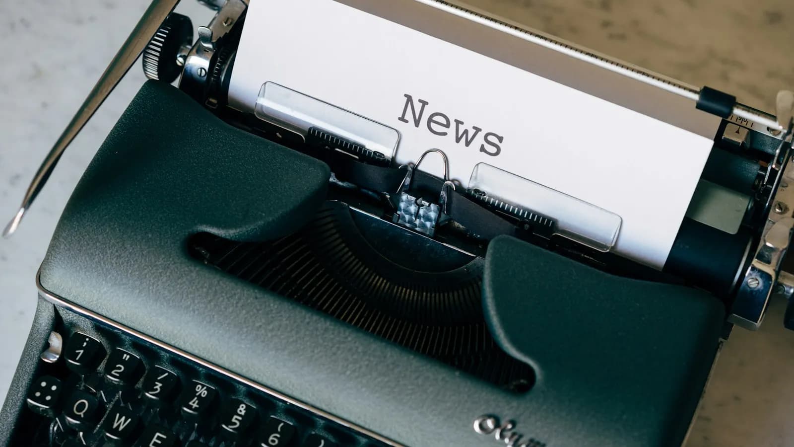 A vintage typewriter with a sheet of paper that reads News