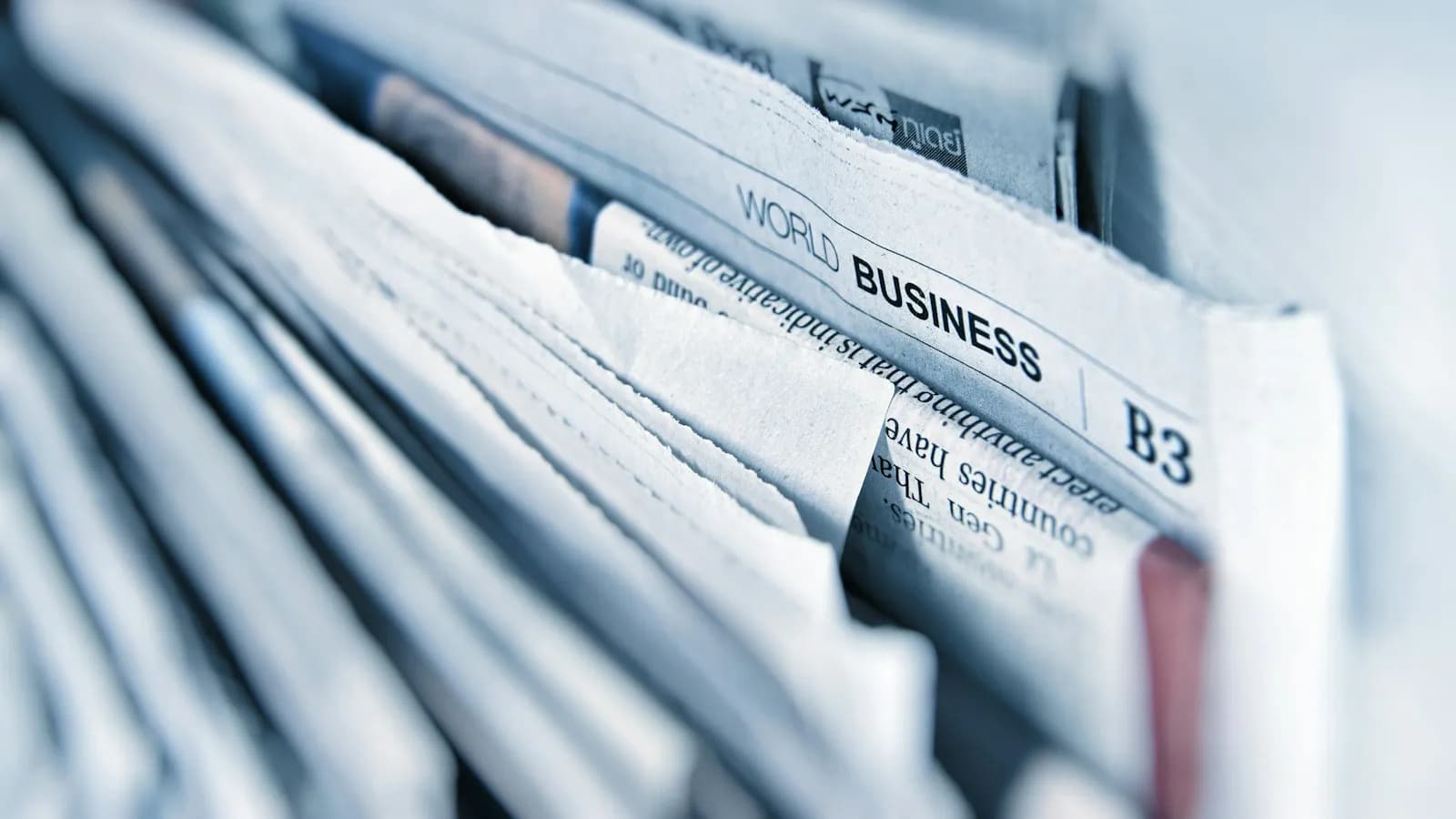 A stack of newspapers with a world business headline in focus