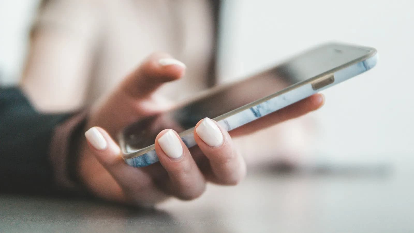 A person holding a smartphone in a bright room